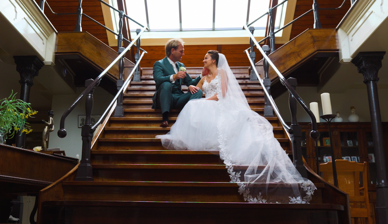 Jeroen en Lyanne zitten samen op een houten trap in een sfeervol landhuis
